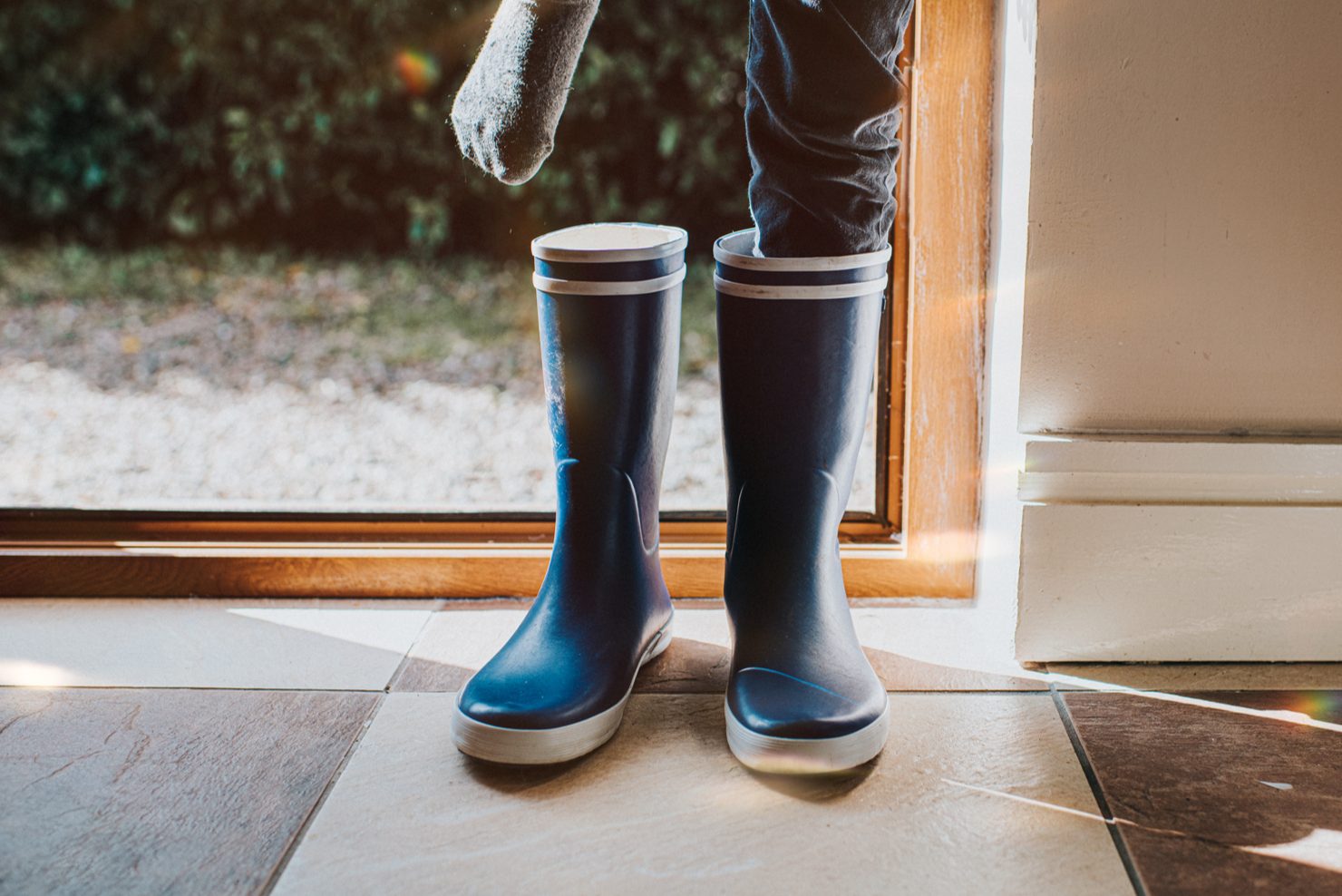 Someone putting on some blue wellington boots